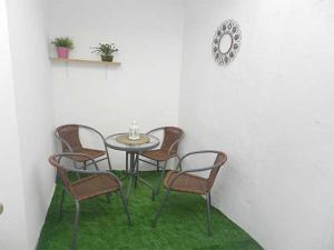 ベヘール・デ・ラ・フロンテーラにあるCasa Mari Carmen, La Plazoletaの緑の芝生のある部屋(テーブル、椅子付)
