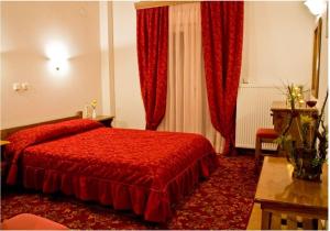 Áyios Nikólaos的住宿－斯皮蒂迪斯帕瑞斯公寓，酒店客房,设有红色的床和红色窗帘
