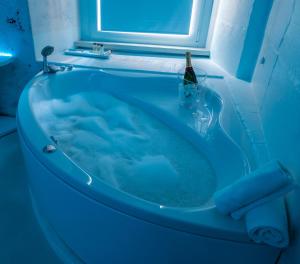 a blue bath tub with a bottle of beer in it at Design&Art Pie' - Spa & Comfort Guesthouse in Rome +18 photos