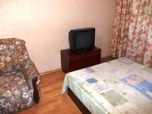 モスクワにあるApartments 4/4のベッド、テレビ、椅子が備わる客室です。