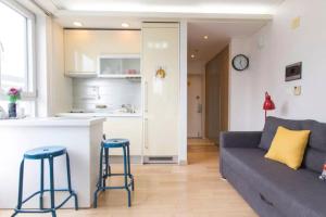 a kitchen and a living room with a couch and stool at Sweet House #2 in Seoul