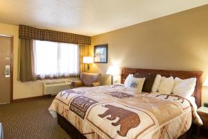 
a hotel room with a bed and two lamps at Crosswinds Inn in West Yellowstone
