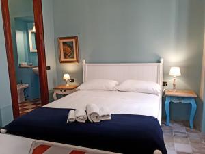 Un dormitorio con una cama con dos zapatos blancos. en Sofia Family Suites en Carloforte