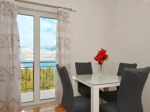jadalnia ze stołem i krzesłami oraz oknem w obiekcie Apartments Uljevic-close to the beach w Trogirze