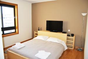 una camera con letto e TV a schermo piatto di Parque Nacoes Prime Apartments 16 - 3 quartos a Lisbona