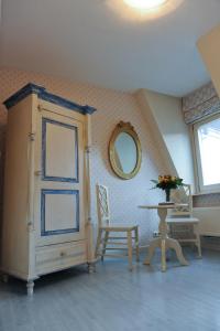 um quarto com um armário, uma mesa e um espelho em Hotel Imperial em Amsterdã