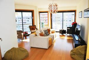 un soggiorno con divano bianco e lampadario pendente di Parque Nacoes Prime Apartments 16 - 3 quartos a Lisbona