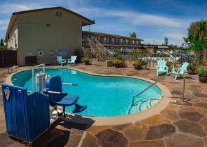 a small swimming pool with chairs and a building at Hotel 414 Anaheim in Anaheim