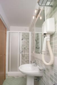 a white bathroom with a sink and a shower at City Hotel in Casoria