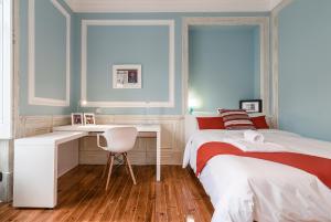 a bedroom with two beds and a desk and a chair at FLH Spacious flats near Avenida da Liberdade in Lisbon