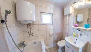 a bathroom with a tub and a sink and a toilet at Apartment Tiger Lily in Mostar +39 photos