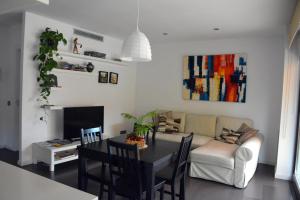 ein Wohnzimmer mit einem Tisch und einem Sofa in der Unterkunft Apartament La Placeta Figueres in Figueres