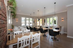 a dining room with tables and chairs and a brick wall at Hotel Barbarossa Classic in Ratingen