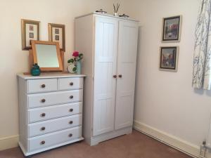 a bedroom with a white cabinet and a dresser at Barons Granary in Rye