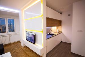 a kitchen with a large window and a tv in it at White Lux apartment in Belgrade