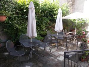 two tables and chairs with umbrellas on a patio at B&B Zia Lina in Dongo