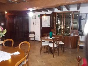 a dining room with two tables and chairs and a cabinet at B&B Zia Lina in Dongo