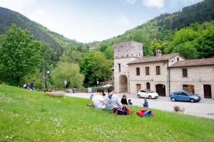 Hotel Terme di Frasassi في جينجا: مجموعة من الناس يجلسون على تلة مع الطائرات الورقية