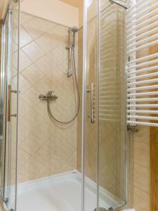 W łazience znajduje się prysznic ze szklanymi drzwiami. w obiekcie Willa Góralskie Spanie w Zakopanem