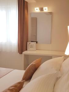 1 dormitorio con espejo y 1 cama con almohadas en Apartments Petričević, en Podstrana