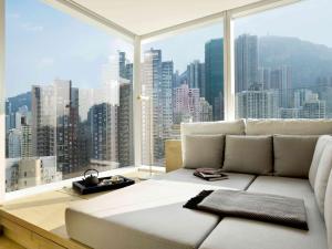 香港にあるザ ジェルヴォワの大きな窓付きの客室で、白い大きなソファが備わります。
