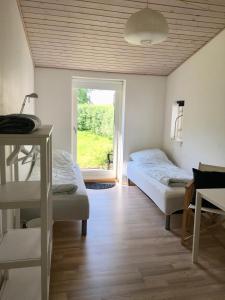 two beds in a room with a window at Tusindfrugt B&B in Store Heddinge