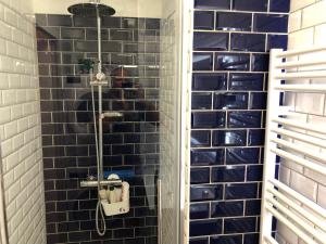 a shower in a bathroom with blue tiles at Sunset lovers in Lacanau-Océan +21 photos