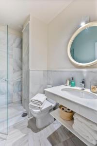 Baño blanco con lavabo y espejo en Apartamento La Catedral, en Sevilla