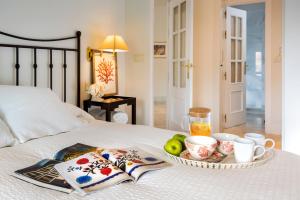 ein Tablett mit Frühstückszutaten und Getränken auf einem Bett in der Unterkunft Apartamento La Catedral in Sevilla