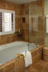 a bathroom with a tub and a glass shower at Brewery Gulch Inn in Mendocino