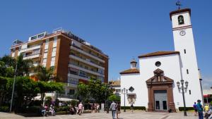 a group of people walking around a clock tower at TuHome Neptuno I in Fuengirola
