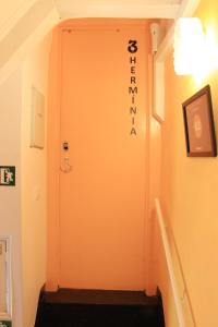 un couloir avec une porte munie d'un panneau. dans l'établissement Casas de Fado, à Lisbonne
