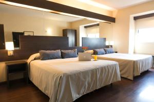 1 dormitorio con 2 camas y ordenador portátil en Hathor Hotels Mendoza, en Mendoza 32 fotos más