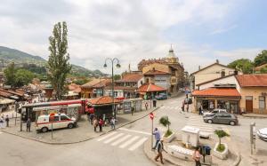 a busy street in a town with a bus at Pigeon Square Rooms in Sarajevo