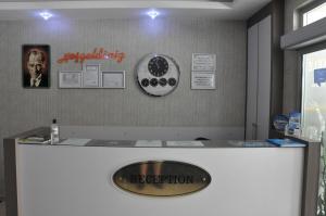 a reception desk with a sign on the wall at İskele Otel in Tasucu
