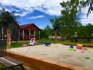 a sandbox with toys in the sand in front of a house at Rodzinna Kraina in Ustka
