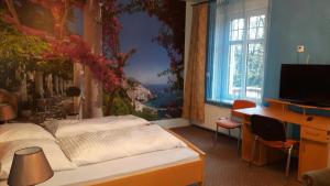 a bedroom with a bed with a painting on the wall at Pałac Ogrodowa in Tarnowskie Góry