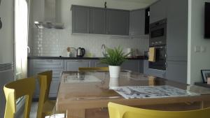 セリにあるF&B's Home Disneyの木製テーブルと黄色い椅子付きのキッチン