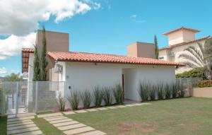 una casa blanca con una valla y un patio en Pousada Suítes do Lago, en Capitólio