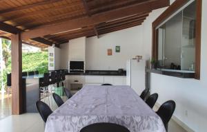 una sala da pranzo con un lungo tavolo e sedie di Pousada Suítes do Lago a Capitólio