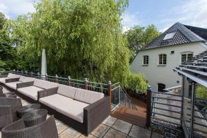 a patio with a couch on a wooden deck at Schnellenburg in Düsseldorf