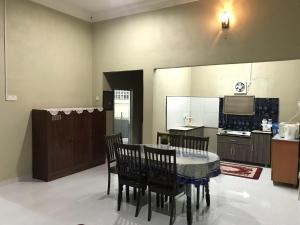 een keuken en eetkamer met een tafel en stoelen bij Homestay HANI in Arau
