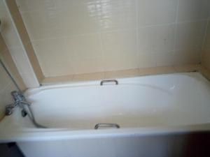 uma banheira branca numa casa de banho com azulejos em Savannah Luxury Apartment em Nairobi