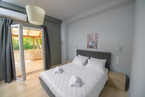 sypialnia z dużym białym łóżkiem i balkonem w obiekcie Prytanio w mieście Olimpia