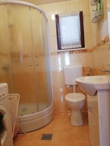 Un baño con ducha, inodoro y lavabo. en Idea Podstrana, en Podstrana
