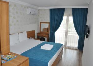 a hotel room with a bed and a window at İskele Otel in Tasucu