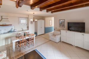a kitchen and living room with a table and a tv at Hotel Abalone in Crikvenica