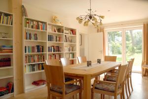 a dining room with a wooden table and bookshelves at Cellino Hotel Prieros in Prieros