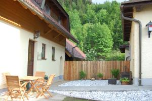 eine Terrasse mit einem Tisch, Stühlen und einem Zaun in der Unterkunft Gasthof Martinihof in Latschach ober dem Faakersee