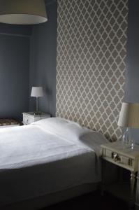 ein Schlafzimmer mit einem weißen Bett und einer Wand in der Unterkunft Wallis São Bento in Lissabon